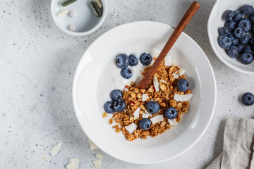 Breakfast and dietary supplements. Granola with yogurt and berries in white plate. Healthy lifestyle concept.