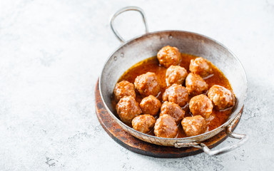 Hot meatballs in tomato sauce in a old frying pan. Homemade food. Copy space.