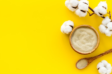 White cosmetic clay on yellow background top-down copy space