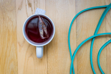 cup of tea with fitness band on wooden table