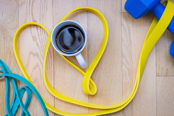 cup of tea with fitness equipment on wooden background