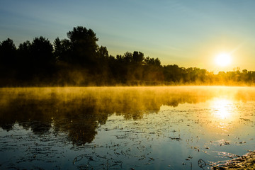 Fog above the water surface. Sunrise at river