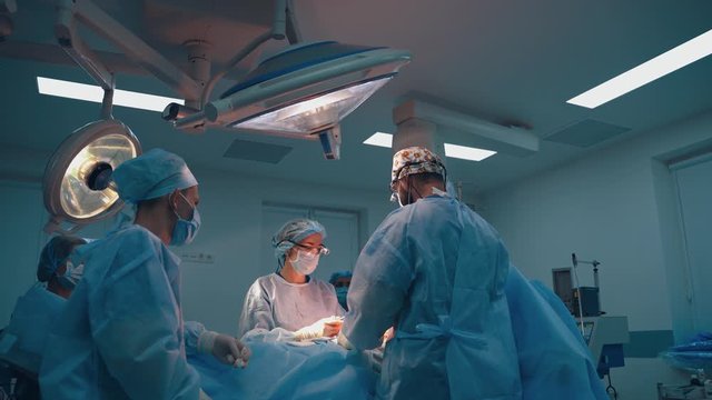 Abdominoplasty of the abdomen. Abdominal liposuction. Partial removal of fat and mucous tissues of the abdomen. The doctor cuts a laser surgical scalpel.