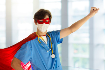 Doctor or nurse in face mask and superhero cape.
