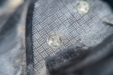 Blurred at high magnification photo of a screw firmly screwed into a metal structure