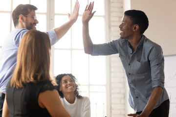 In boardroom gathered businesspeople diverse guys buddies greets giving high five express amity. Team members multi-ethnic leaders congratulate each other with common success, respect gesture concept