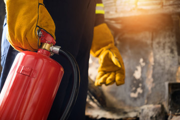 Close up hand Fireman,Firefighter holding the fire extinguisher.