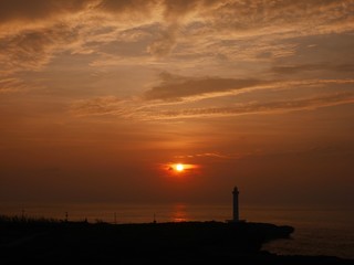 赤く染まる夕焼け空と灯台のシルエット