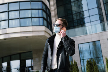 Handsome businessmanin with medical mask on the street  talking on the cellphone.  quarantine concept .