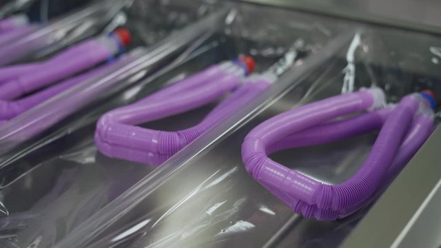 Production of medical oxygen equipment, woman at work, the process of packaging plastic tubes for breathing equipment.