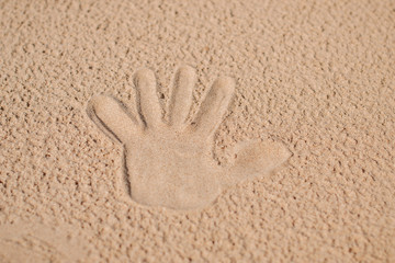Imprint, handprint on clean sand. Summer holidays on the sandy beach.