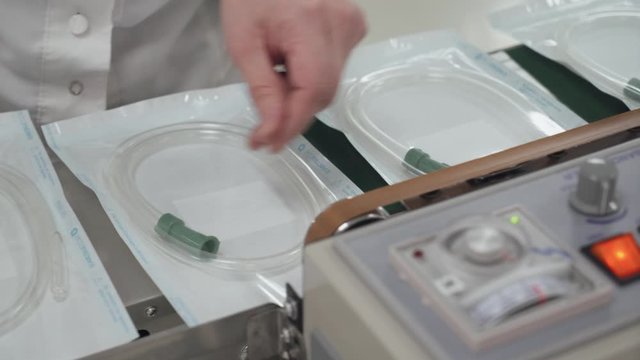 Production of medical oxygen equipment, woman at work, the process of packaging tubes for breathing equipment.