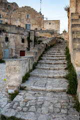 Fototapeta premium Typical cobbled stairs in a side street alleyway iin the Sassi di Matera a historic district in the city of Matera. Basilicata. Italy
