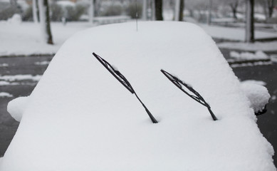 Car covered with snow on street in winter