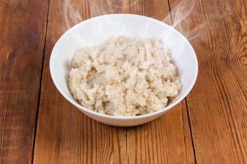 Hot barley porridge in bowl on the rustic table