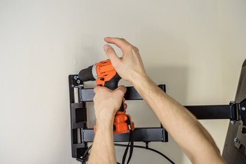 Man hands installing mount TV on the wall