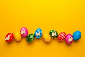 Bright easter eggs with bunny (rabbit) on yellow background. Retro colorful spring decoration.