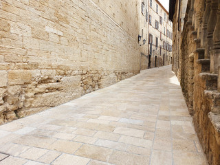 A narrow, deserted street in San Marino with ancient, stone houses.