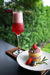 Strawberry short cake served with a glass of mixed berry cocktail drink