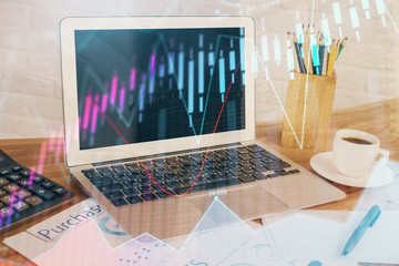 Stock market graph on background with desk and personal computer. Multi exposure. Concept of financial analysis.