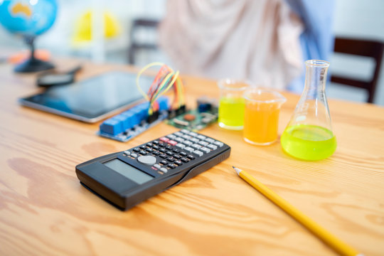 Calculator for Stem educations, Student learning in chemistry science education class makes chemistry experiment lab. STEM , mechanic, chemistry test, biology.Microscope and test tubes in a laboratory