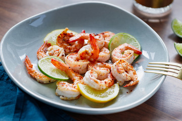 Fototapeta na wymiar Fried tiger shrimp with lime, lemon and spices on a ceramic dish. Healthy dinner or lunch concept.