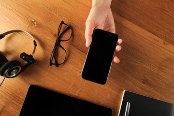 Female hands working on wooden work place with modern gadgets  top view .