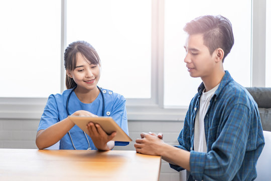 Asian Female Doctor Showing Patient Diagnosis On Health By Pointing Finger On Tablet Device Showing Information Such As Heart Rate Diagram To Explain And Help Patient Understanding Health Illnesses