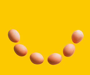 The eggs are arranged in a smile shape on a separate yellow background