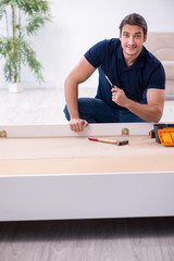 Young male contractor installing furniture at home