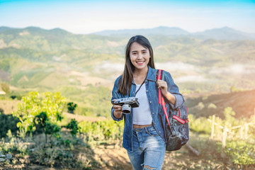asian tourist traveler girl in an adventure traveling on the mountains, using a digital camera...