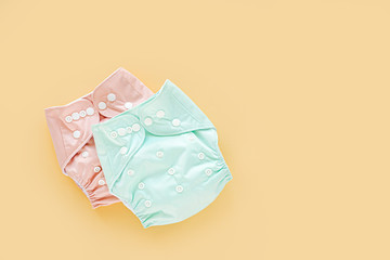 Reusable cloth baby diapers. Eco friendly cloth nappies on a yellow background. Sustainable lifestyle.  Zero waste concept.