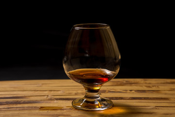 glass with cognac on a black background