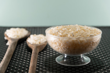White corn for hominy preparation in wooden spoon on black background