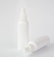 White bottles of sanitizer or liquid soap for hand hygiene to protect from corona virus over white background