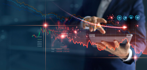 Economic crisis, Businessman using tablet analyzing sales data and economic graph chart that is...