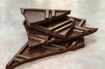 Dark chocolate bar pieces on marble table