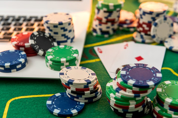 Chips, cards money and laptop for poker online or casino gambling. Risk for win money.