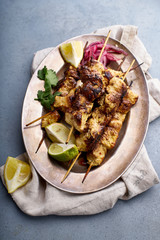 Chicken tikka kebab with marinated onion, fresh salad and yoghurt sauce. Traditional indian cuisine, delicious starter. Creative flatlay