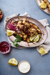 Chicken tikka kebab with marinated onion, fresh salad and yoghurt sauce. Traditional indian cuisine, delicious starter. Creative flatlay