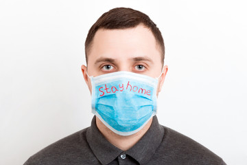 Portrait of young man wearing medical mask Stay home at white background. Coronavirus self isolation concept. Respiratory protection