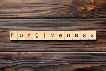 forgiveness word written on wood block. forgiveness text on table, concept - obrazy, fototapety, plakaty