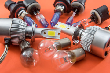 Different shapes and sizes car light bulbs isolated on orange. Modern auto glass lamp
