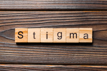 stigma word written on wood block. stigma text on table, concept
