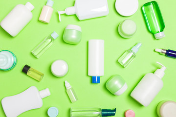 Group of plastic bodycare bottle Flat lay composition with cosmetic products on green background empty space for you design. Set of White Cosmetic containers, top view with copy space