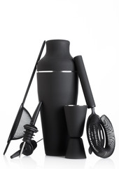 Luxury matte black coloured cocktail set with shaker and strainer, pourer and measuring jigger on white.
