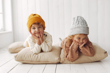 Children in a studio. Little girl with her brother. Boy in a white sweater.