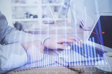 Multi exposure of stock market chart with man working on computer on background. Concept of financial analysis.