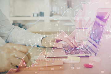 Multi exposure of stock market graph with man working on laptop on background. Concept of financial...