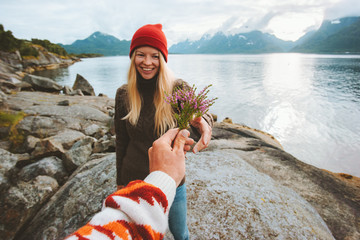 Couple in love man hand giving bouquet flowers to woman travel lifestyle romantic vacations in Norway relationship feelings concept